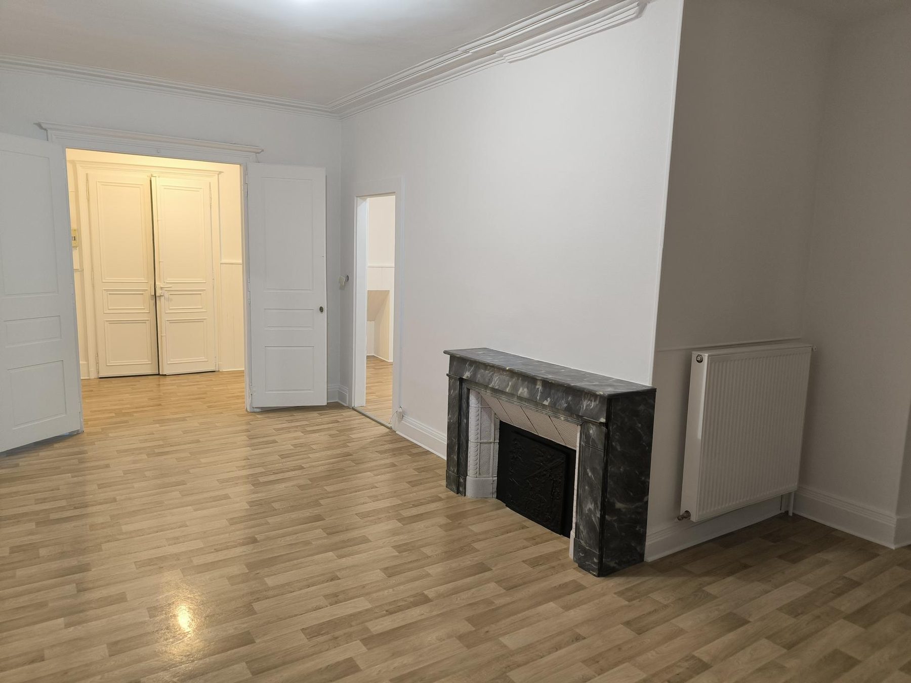 Pièce ancienne, cheminée de marbre et portes moulurées